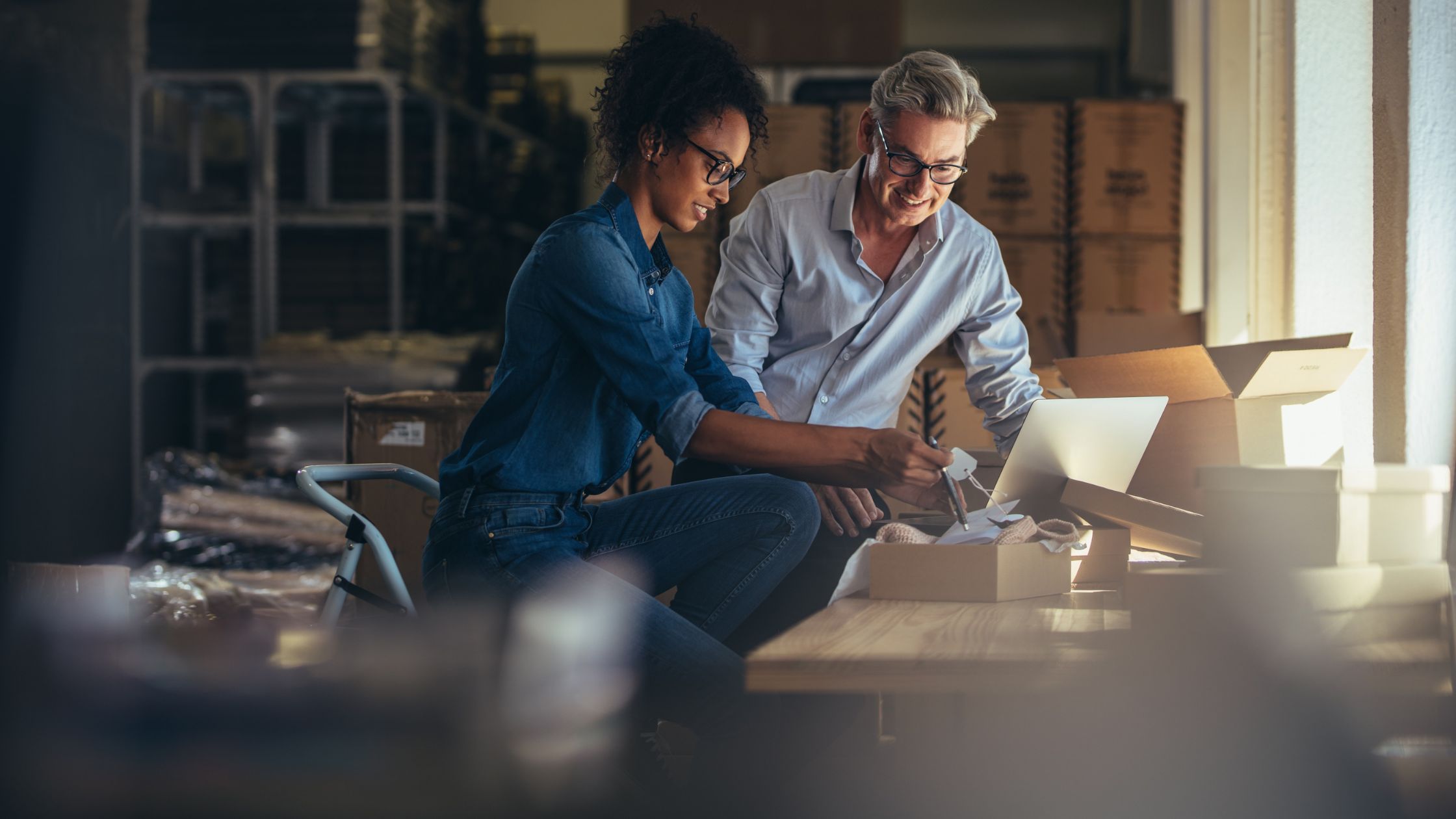 Two business owners reviewing an order together in their warehouse