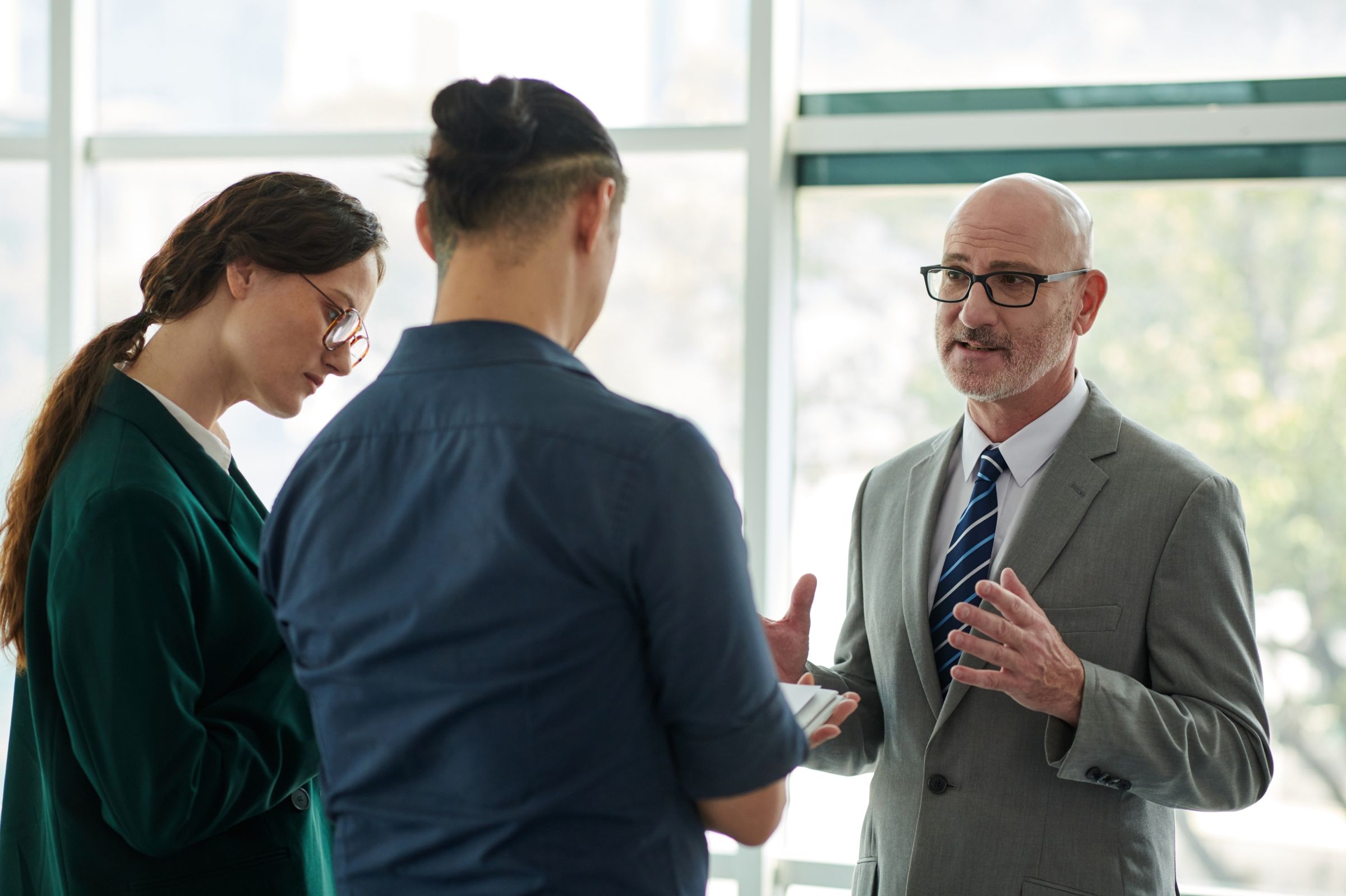 An advisor talking with two colleagues in a bright office